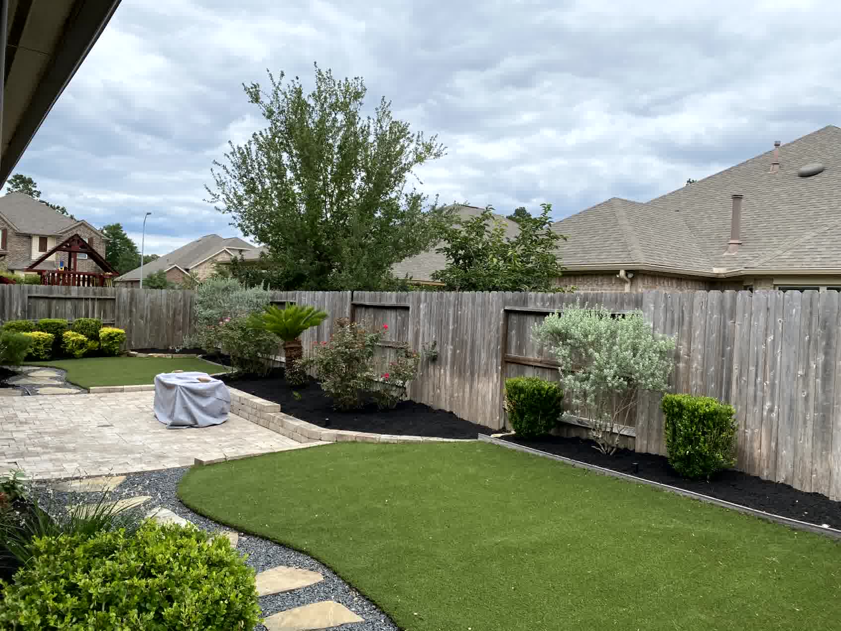 cut n edge spring fencing landscaping -Cut'N Edge Property Management Backyard with fresh sod, curved hardscape edging, mulch beds, shrubs, and low-maintenance landscaping for a clean, modern look.